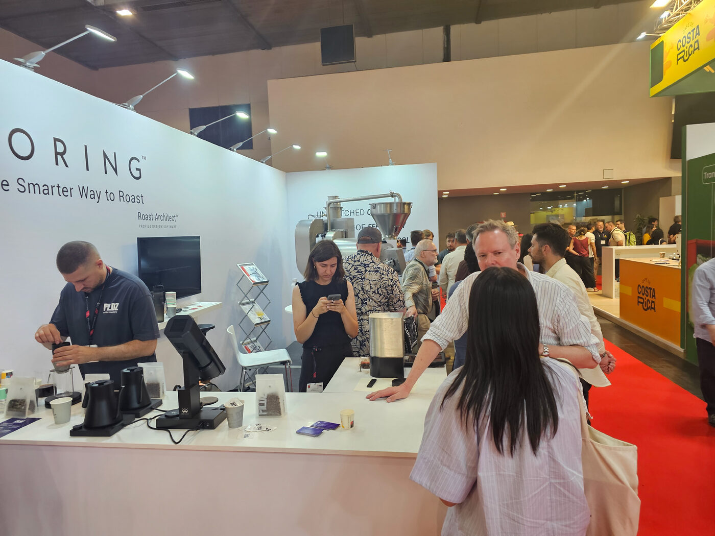 Visitors exploring coffee equipment at an exhibition